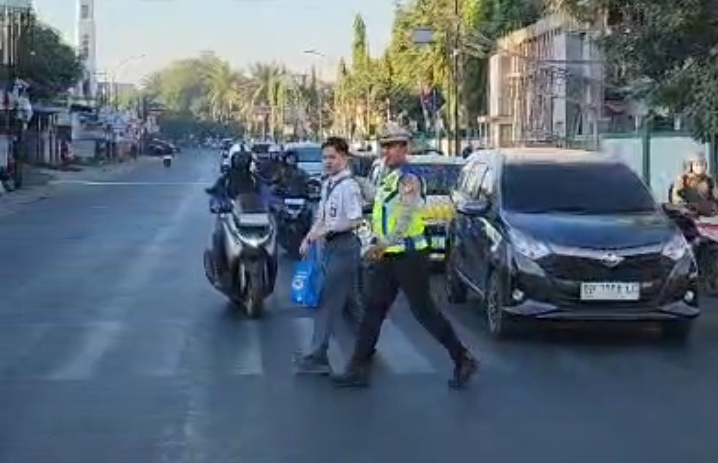 Utamakan Keselamatan dan Pelayanan, Kasat Lantas Polresta Gowa Gandeng Anak Sekolah Menyebrang